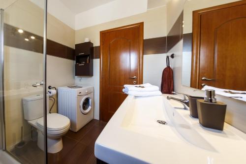 bagno con lavandino bianco, servizi igienici e lavandino di Dimitras House a Ágios Nikólaos