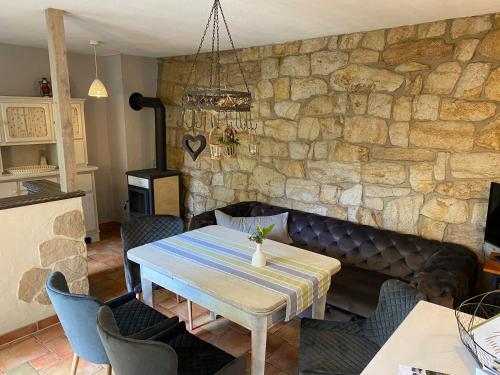 a dining room with a table and a stone wall at Wanderer Paradies in Pirna