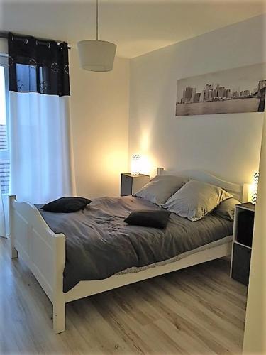 a bedroom with a large bed with a window at "bienvenue" appartement T2 meublé in Savigny-le-Temple