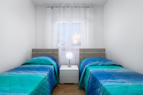 1 Schlafzimmer mit 2 Betten und einem Fenster in der Unterkunft Stancija Amorozo 5 in Poreč
