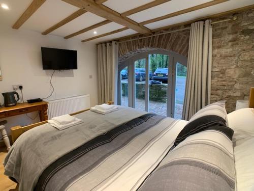 a bedroom with a large bed and a television at Swan House Tea Room and Bed & Breakfast in Lydney