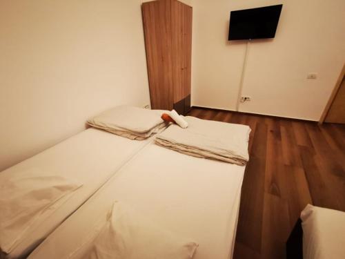 Central Accommodation PIATA ROMANA في بوخارست: غرفة نوم صغيرة مع سرير مع ملاءات بيضاء