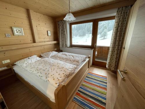 a bedroom with a bed and a large window at Landhaus Zillertal in Ramsau im Zillertal