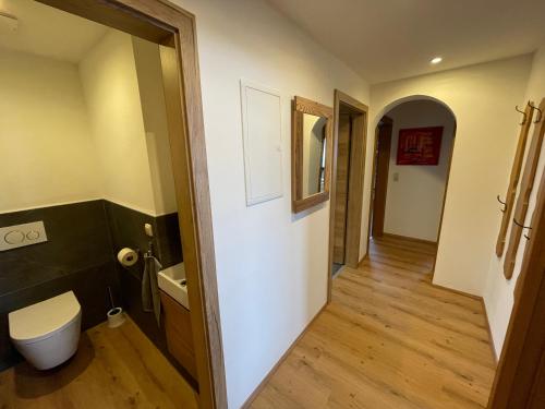 a bathroom with a toilet and a hallway at Landhaus Zillertal in Ramsau im Zillertal