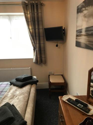 a bedroom with a bed and a tv and a desk at Cozy lodge with private garden and bbq in Barton-upon-Humber