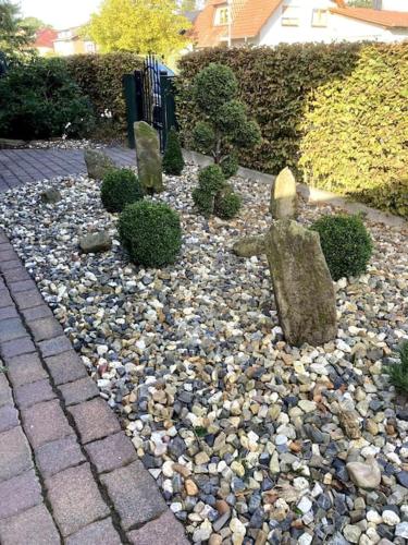 a garden with a statue of a person on rocks at Gemütliches Landhaus in ruhiger Lage. in Moringen