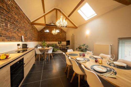 a kitchen and dining room with a table and chairs at B&B Haspenhoeve in Tongeren
