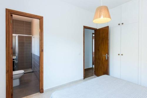 a bedroom with a bed and a bathroom with a toilet at Apartamento Sa Mesquida 11 in Cala Llonga