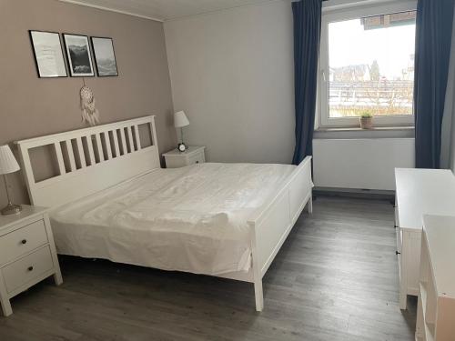 biała sypialnia z białym łóżkiem i oknem w obiekcie Diamant Apartment w mieście Gattendorf