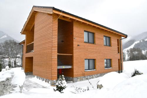 a wooden house in the snow with snow at Apartmány Tatry Žiarce in Liptovský Mikuláš