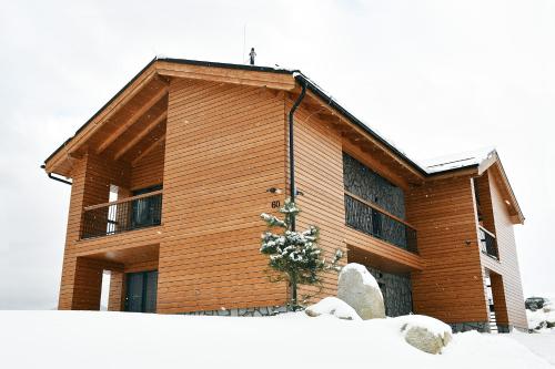 a wooden building with snow in front of it at Apartmány Tatry Žiarce in Liptovský Mikuláš
