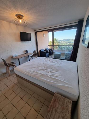 une chambre avec un lit et une vue sur un balcon dans l'établissement Les Terrasses, à Bormes-les-Mimosas