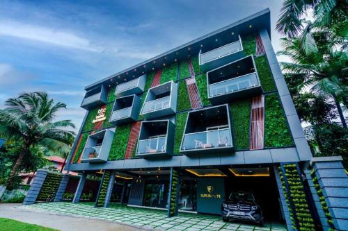 a green building with a car in front of it at BBC Luxury Apartments in Perintalmanna