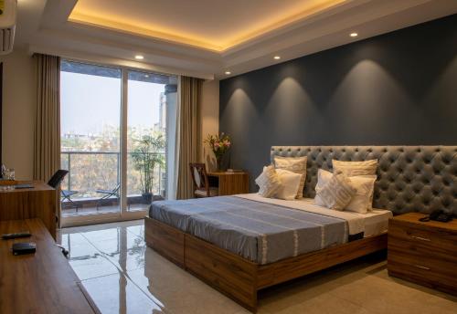 een slaapkamer met een groot bed en een groot raam bij Perch Service Apartment-MG Road in Gurgaon