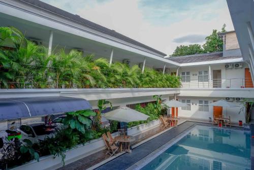 a hotel with a swimming pool and a courtyard with plants at Urbanview Hotel Syariah Casa Azmya Yogyakarta by RedDoorz in Kejayan
