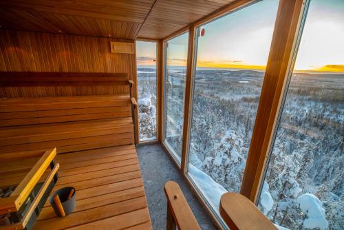 an empty sauna with a view of the snow at Lapland View Lodge in Övertorneå