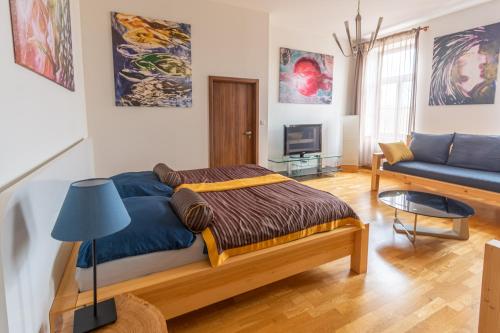 Un dormitorio con una cama y un sofá azul. en Apartment Sirius C in center of CB., en České Budějovice