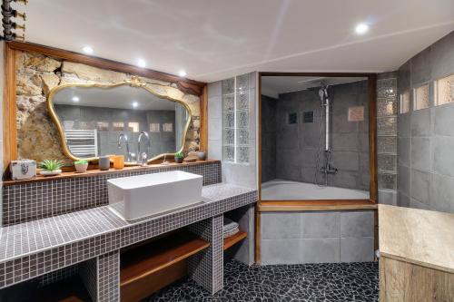 La salle de bains est pourvue d'un grand miroir et d'un lavabo. dans l'établissement Central & Atypique T3 Parking privé Opera/Terreaux, à Lyon