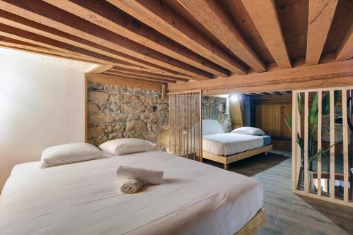 a bedroom with two beds and a stone wall at Central & Atypique T3 Parking privé Opera/Terreaux in Lyon