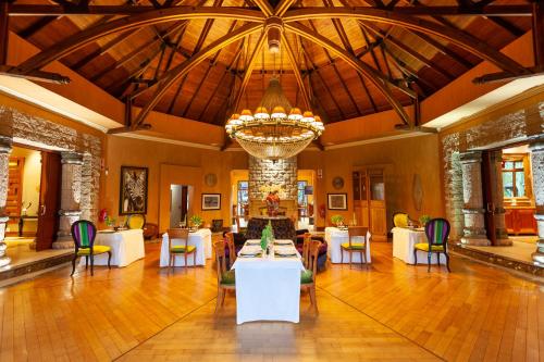 a dining room with tables and chairs and a chandelier at Lejwe La Metsi Private Reserve in Bela-Bela