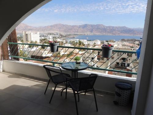a table and chairs on a balcony with a view at Lev Eilat Suites in Eilat