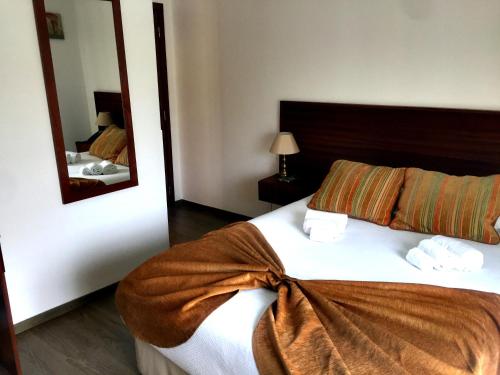 a bedroom with a large bed with a large mirror at Hotel Louro in Óbidos
