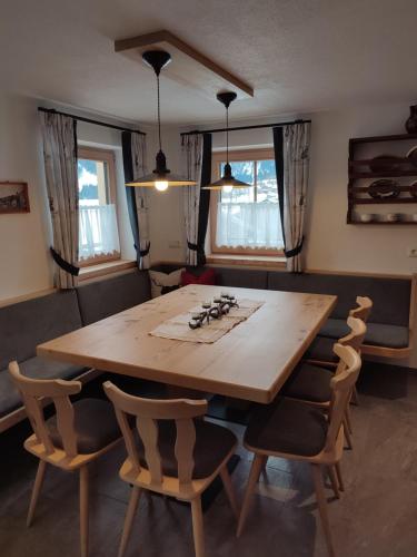 a dining room with a wooden table and chairs at Veitenhof in Krimml