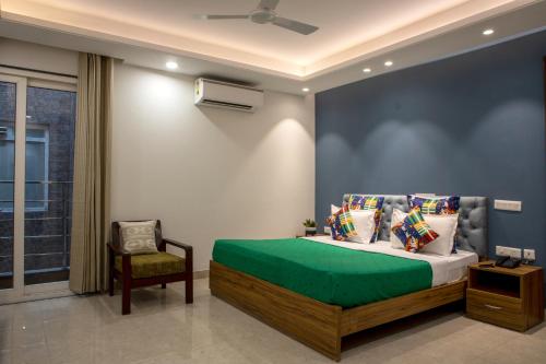 a bedroom with a bed and a chair in it at Perch Service Apartment-MG Road in Gurgaon