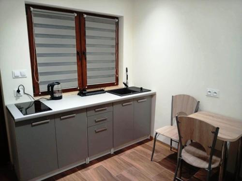 cocina con fregadero, ventana y mesa en Pod Miejską Górą, en Bodzentyn