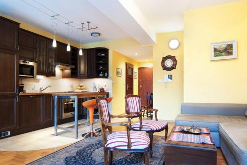 a kitchen and living room with two chairs and a couch at Trinity Apartment in Krakow