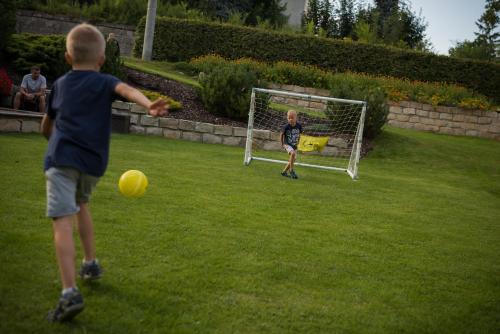 a young boy kicking a soccer ball in a field at Apartmány Adršpach " U Kozárů " in Adršpach