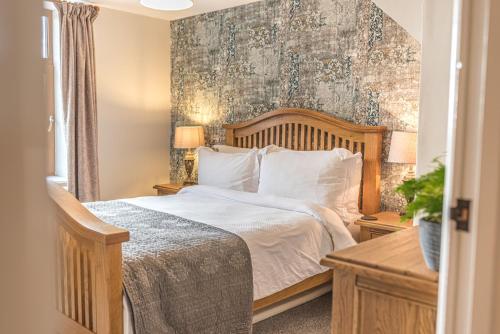 um quarto com uma cama grande e uma parede em The Black Dog Cottage em Dalton in Furness