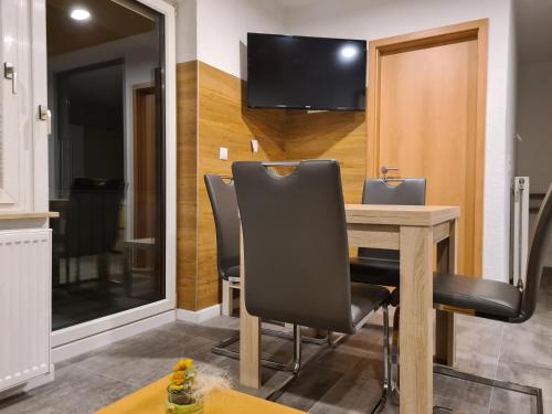 comedor con mesa, sillas y TV en Exklusive moderne 2 Zi. Wohnung in ruhiger Lage, en Schechingen