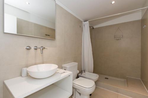 a bathroom with a sink and a toilet and a shower at De la Costa Apartamentos in Ushuaia