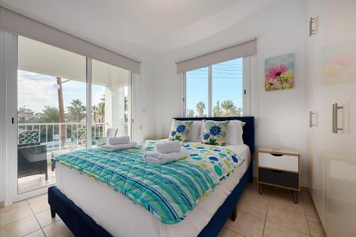ein Schlafzimmer mit großem Bett und Balkon in der Unterkunft Villa Haven by Ezoria Villas in Coral Bay