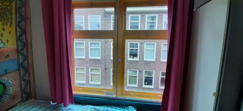 a bedroom with a window with pink curtains at MICHELLE, not for parties, not a hotel, room with shared bathroom, no kitchen in Amsterdam