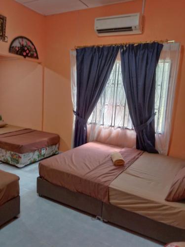 a bedroom with two beds and a window at CHALET WARISAN SINERGI in Lubuk Cina