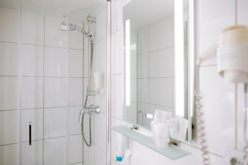 a bathroom with a shower and a mirror at Boutique Hotel Villa Oberkassel in Düsseldorf