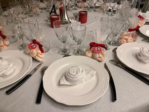 a table with white plates with roses on it at Demeure des Vieux Bains in Provins