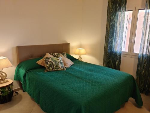 une chambre avec un lit vert avec deux oreillers dans l'établissement LIMONE, à Conca