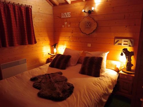 La Cabane à l'Orée des Bornes في Évires: غرفة نوم بسرير كبير مع شراشف بيضاء