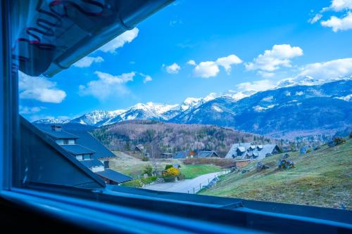 a view of a mountain range from a window at Apartments Bohinj Mavrica in Bohinj
