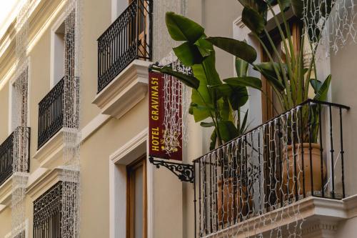 un edificio con balcón y una planta en Hotel Gravina 51 en Sevilla