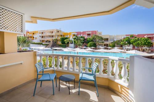 a balcony with chairs and a swimming pool at Allegro Isora in Puerto de Santiago