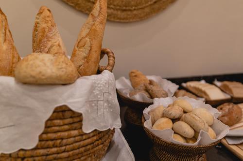 un grupo de cestas de pan y bollería sobre una mesa en Hotel Gravina 51 en Sevilla
