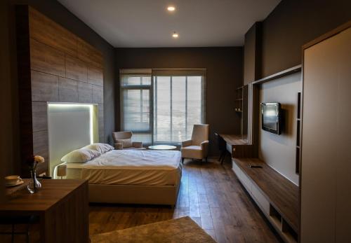 a bedroom with a bed and a desk and a tv at Bureau Residence in Kartepe