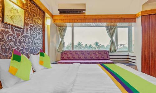 a bedroom with a large bed with a purple couch at Treebo Sahara Shivaji Nagar in Pune