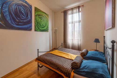 a bedroom with a bed and a painting on the wall at Apartment Sirius C in center of CB. in České Budějovice