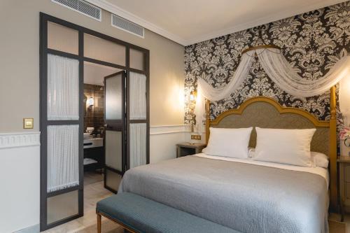a hotel room with a large bed and a large window at Hotel Gravina 51 in Seville