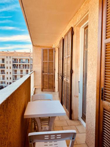 un balcon avec une table et des chaises sur un immeuble dans l'établissement Joli deux pièces, centre ville et proche plage, à Propriano